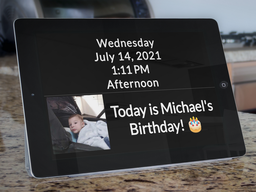 A RecallCue day clock displaying the date and a birthday photo message